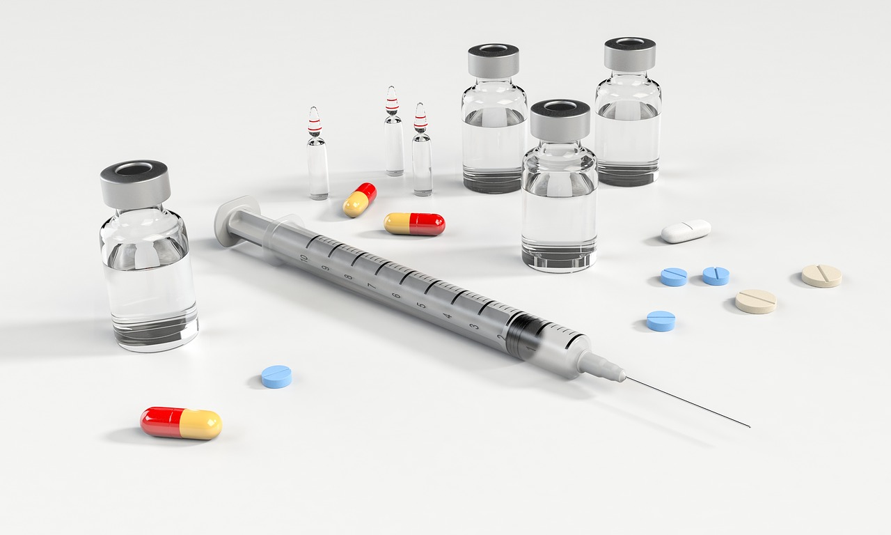 A fluid filled syringe with pills surrounding it.