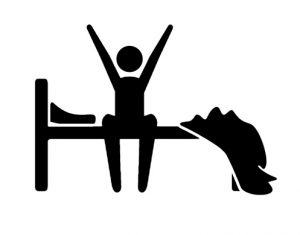 A silhouette of a person stretching their arms and dangling their legs on the side of the bed.