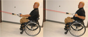 Man in wheelchair performing a one-arm row using a resistive band.