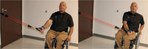 Man in wheelchair performing resisted adduction exercise (pull-down and across the body with the elbow starting no higher than the shoulder).