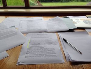 Piles of papers with a pen on a desk