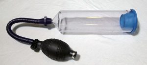 A penile vacuum device with a clear chamber and pump on one end