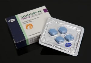 A box and blister pack of blue Viagra pills